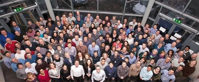 A photo of the Ocuco staff from an elevated point of view. All staff members are looking up at the camera smiling.
