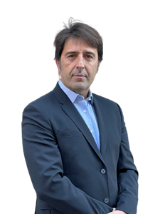 A photo of Angelo Furlotti, He has dark brown hair and is wearing a light blue button up shirt with a navy blue blazer.