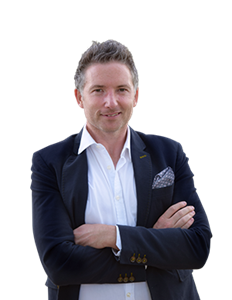 A photo of James Loughman. He is wearing a white shirt and black blazer with his arms crossed.
