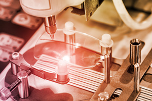An image of a lens being held by a machine in an optical lab.